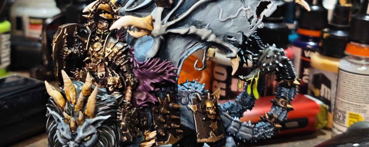 Painted Chaos Lord riding a Manticore, with pale blue wings and an unfinished base.