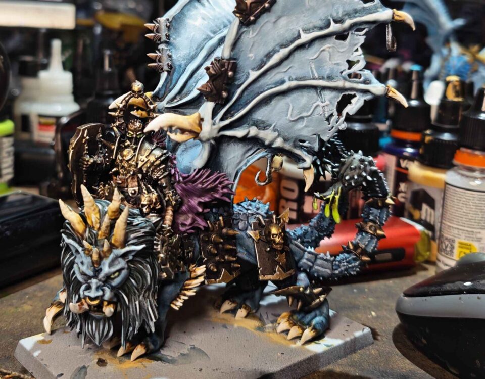 Painted Chaos Lord riding a Manticore, with pale blue wings and an unfinished base.