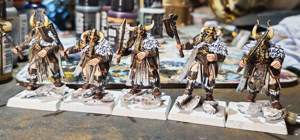 Five painted northern warriors with horned helmets, pale fur cloaks and unfinished rocky bases. Five painted northern warriors with horned helmets, pale fur cloaks and unfinished rocky bases.